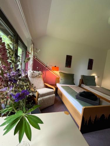 a bedroom with a bed and a couch and a table at Waldgarten Marienau in Höchenschwand