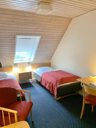 a hotel room with two beds and a window at Agerskov Kro & Hotel in Agerskov