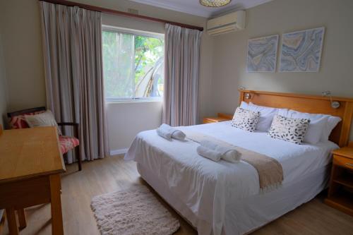 a bedroom with a bed with white sheets and a window at Lakeview Cabanas - Unit 5 in St Lucia