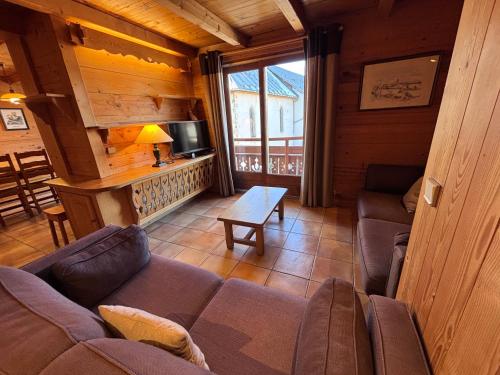 a living room with a couch and a tv in a cabin at Appartement Chez Marion in Notre-Dame-de-Bellecombe