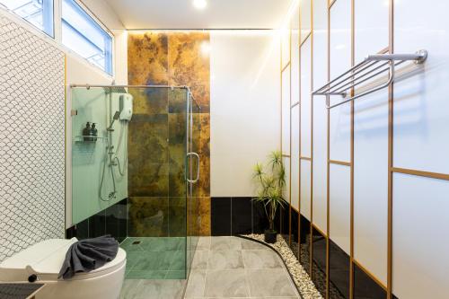 a bathroom with a glass shower and a toilet at Towa Onsen and Ryokan in Ban Nong Tangme