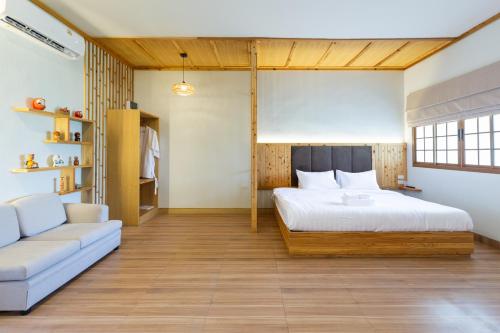 a bedroom with a bed and a couch at Towa Onsen and Ryokan in Ban Nong Tangme