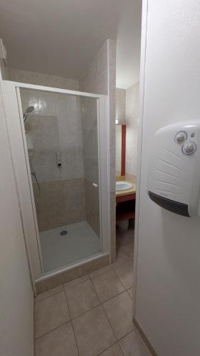 a shower with a glass door in a bathroom at Résidence Serre-Ponçon in Chorges
