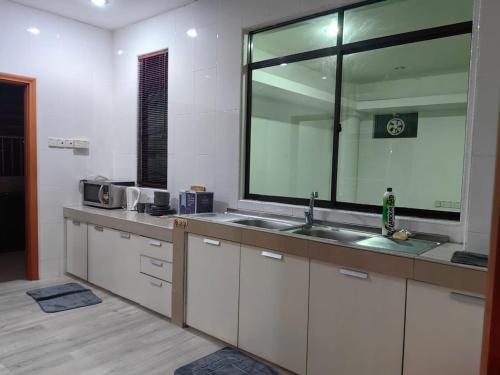 a kitchen with a sink and a large mirror at Stay181 Bintulu in Bintulu