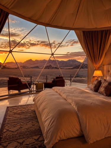 a bedroom with a bed with a view of the desert at Wadi Rum Luxury Hamad & Jeep Tours in Wadi Rum