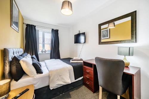 a bedroom with a bed and a desk and a chair at Bright 4 Bedroom Home in Walsall, Free Parking and for EVs in Walsall