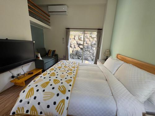 a bedroom with a large bed and a flat screen tv at 藍屋頂民宿Blue Dome in Puli