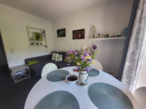 a living room with a white table with flowers on it at Family Apartment, 2 Bedrooms, 2 Bathrooms, Bavarian Forest in Mitterfirmiansreut