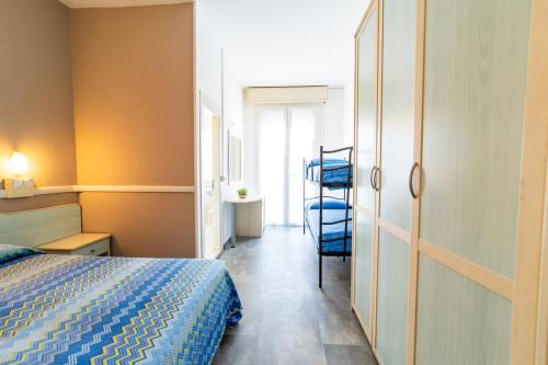 a bedroom with a bed and a chair in it at Hotel Carol in Cesenatico