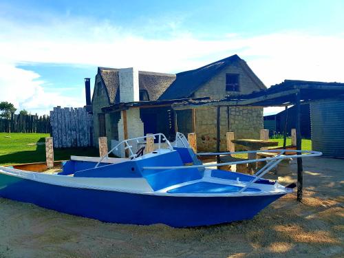 a blue boat sitting in front of a house at Affi lande Boetiek guestfarm in Fouriesburg