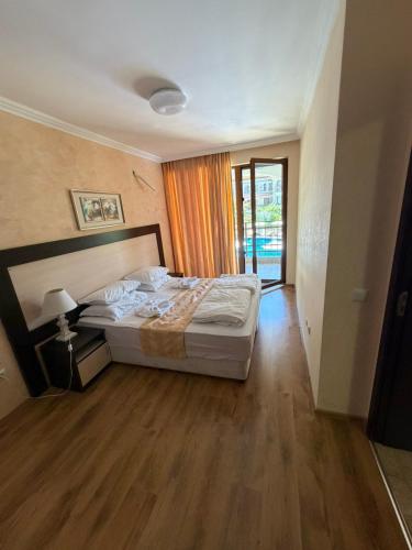 a bedroom with a bed and a wooden floor at Premium Apartments in Sveti Vlas