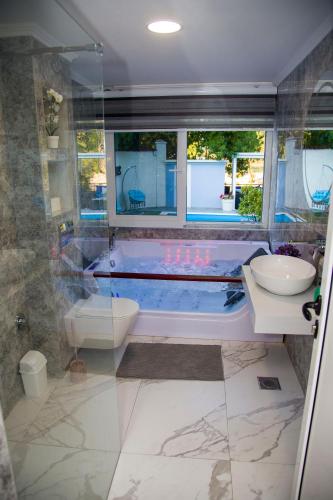 a bathroom with a tub and a toilet and a sink at Private Riverside Villa Silvia in Mostar