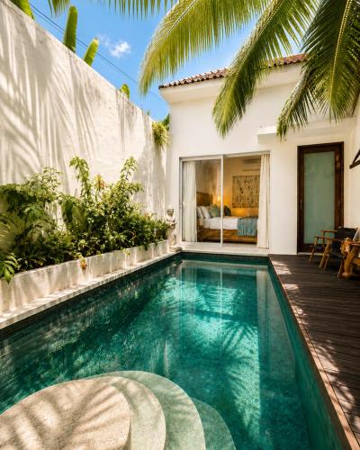 a swimming pool in front of a house at Eve Evy Private Pool Villas in Nusa Lembongan