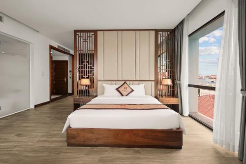 a bedroom with a large bed and a large window at MT Collection Hotel in Ninh Binh