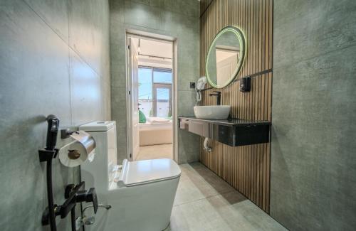 a bathroom with a toilet and a sink and a mirror at Qafqaz Four Seasons in Gabala