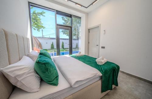 a bedroom with a large bed with green and white pillows at Qafqaz Four Seasons in Gabala