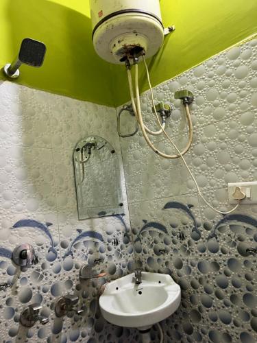 a bathroom with a sink and a shower at Hotel Lotus in Banbāsa