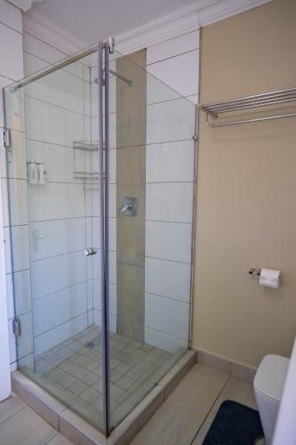 a shower with a glass door in a bathroom at Lakeview Cabanas - Unit 5 in St Lucia