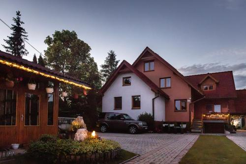 a house with a car parked in front of it at Penzion JAS in Zuberec