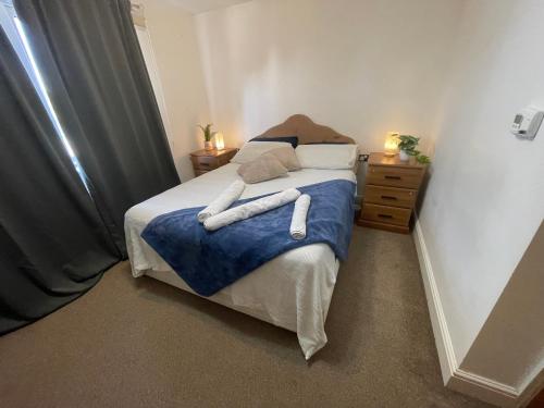a bedroom with a bed with two towels on it at Cozy En-Suite Room with full Home Access in Harrow