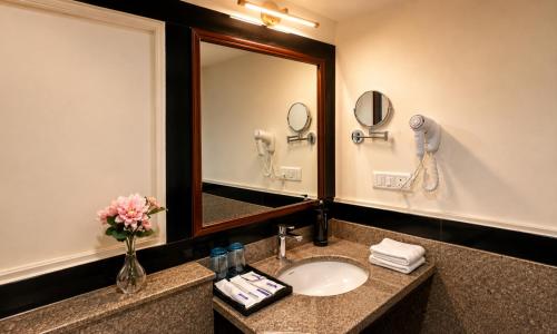 a bathroom with a sink and a mirror at Ello Hotels in Bangalore