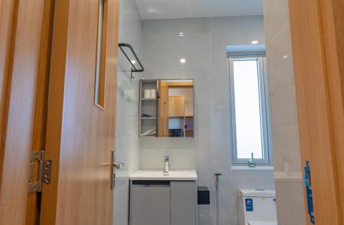 a bathroom with a sink and a mirror and a window at Minh Khang Apartment in Danang