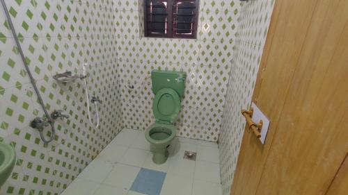 a bathroom with a green toilet and a sink at Sivadurga in Varkala