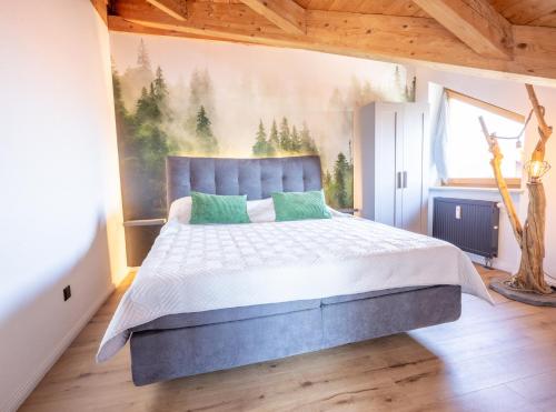 a bedroom with a bed with a painting on the wall at Apartment Bergraum - familienfreundlich und zentral in Sankt Englmar