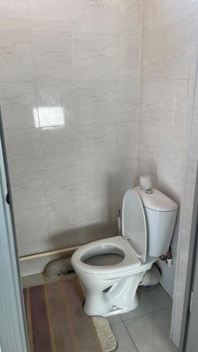 a bathroom with a white toilet in a room at Guest Home in Jalal-Abad