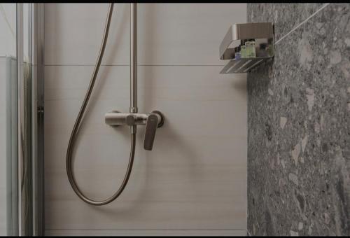 a shower with a hose attached to a wall at Dimitra Suites in Pythagoreio