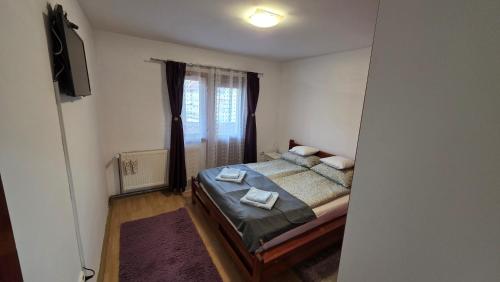 a bedroom with a bed with two towels on it at Apartament Balto in Borsec