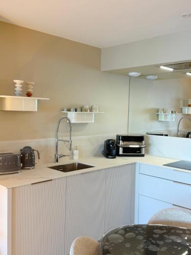 a kitchen with a sink and a counter top at Escale élégante à la mer Duplex neuf en front de mer in Bénodet