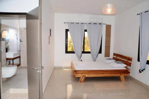 a white bathroom with a bed and a window at VILLA ÉKÉ Baguida plage in Baguida