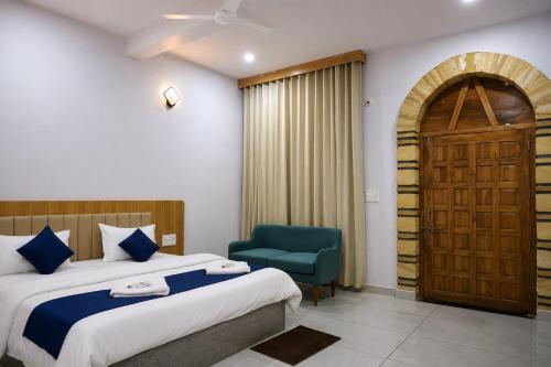 a bedroom with a bed and a chair and a door at Gir Vintage Villa in Sasan Gir