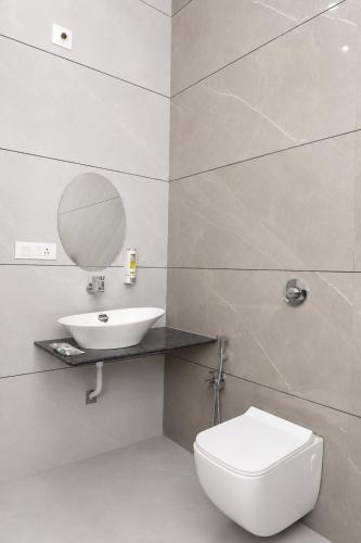 a bathroom with a toilet and a sink and a mirror at Gir Vintage Villa in Sasan Gir