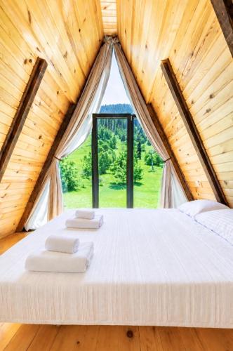 a bed in a wooden room with a window at Hatsvali Gate in Mestia