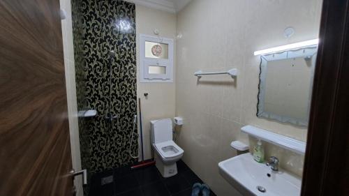 a bathroom with a toilet and a sink and a mirror at حياة النعيم in Salalah