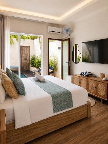a bedroom with a large bed and a television at Eve Evy Private Pool Villas in Nusa Lembongan