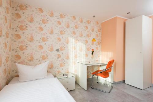 a bedroom with a bed and a desk and a chair at Appartements am Kleeblatt in Wuppertal
