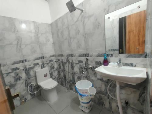 a bathroom with a sink and a toilet and a mirror at Hotel Abhijeet Inn in Raipur