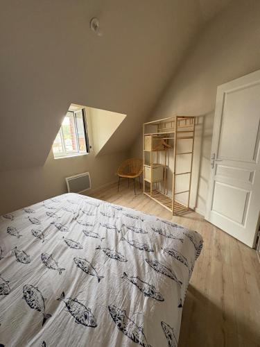 an attic bedroom with a bed and a window at Le Petit Bleu - Charming House in Yport