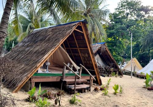 a group of tents on a beach with palm trees at Long Beach Camp in Perhentian Islands