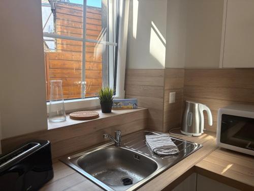 a small kitchen with a sink and a window at Le Petit Bleu - Charming House in Yport