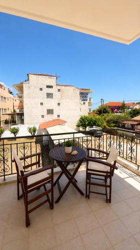 a patio with a table and chairs on a balcony at Hemithea Nidri Rooms in Nydri