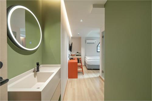 ein Badezimmer mit Waschbecken und Spiegel an der Wand in der Unterkunft Jace Siam Hotel in Bangkok