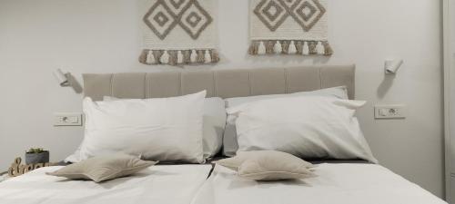 a bed with white sheets and pillows on it at Villa Ulika in Fažana