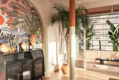 a living room with palm trees and a black cabinet at INVIS Urban High-rise Suites in Chengdu