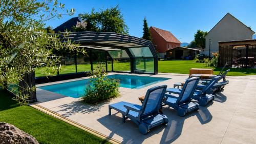 a group of chairs sitting next to a swimming pool at Gite oncle Yerry in Ostheim