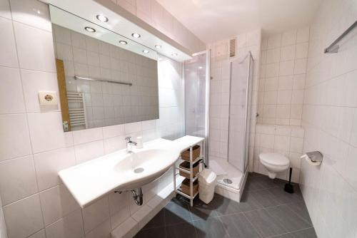 a white bathroom with a sink and a toilet at Germania-29 in Böhl