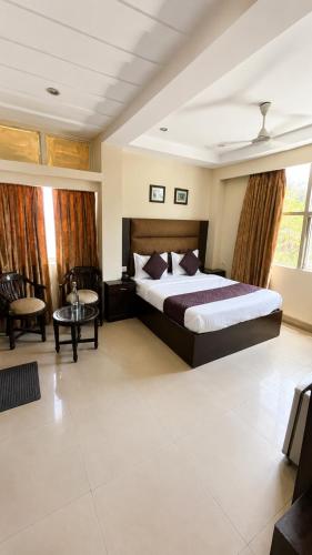 a hotel room with a bed and a table at Hotel Rio Haridwar in Haridwār
